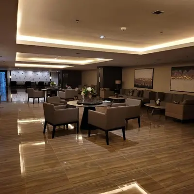 a hotel lobby with chairs and a table with flowers on it at Air Residences - Pool View near Airport - 1159 in Manila