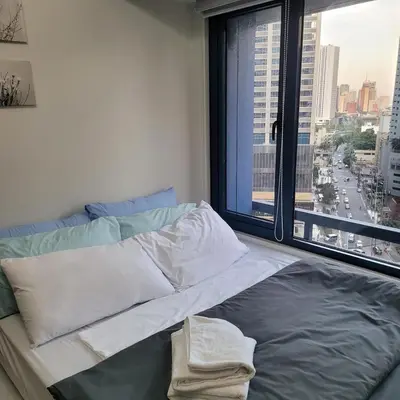 a bed in a room with a large window at Air Residences - Pool View near Airport - 1159 in Manila