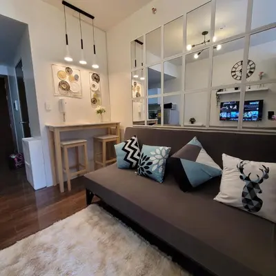 a living room with a couch with pillows at Air Residences - Pool View near Airport - 1159 in Manila