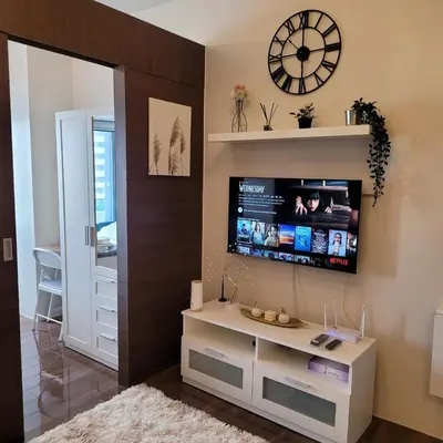 a living room with a tv on a wall at Air Residences - Pool View near Airport - 1159 in Manila