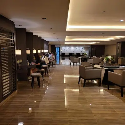 a lobby of a hotel with people sitting at tables at Air Residences - Balcony City View near Airport - 3521 in Manila