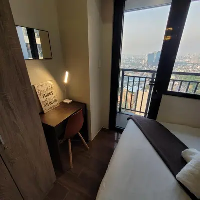 a bedroom with a desk and a bed and a window at Air Residences - Balcony City View near Airport - 3521 in Manila