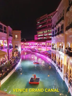 a venice grand canal at night with people in a boat at Chic BGC Condo by Grand Canal Mall #vlrtb27b in Manila
