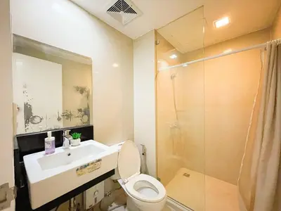 a bathroom with a sink and a toilet and a shower at Chic BGC Condo by Grand Canal Mall #vlrtb27b in Manila