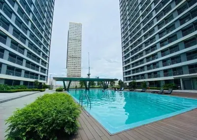 a large swimming pool in the middle of two buildings at One Bedroom Condo Unit Fame Residences Tower 4 in Manila