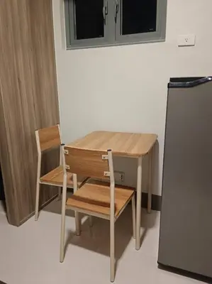 a wooden table and two chairs and a refrigerator at One Bedroom Condo Unit Fame Residences Tower 4 in Manila