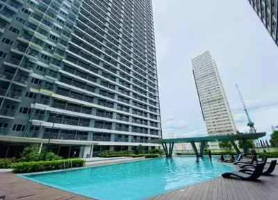 a swimming pool in front of a large building at One Bedroom Condo Unit Fame Residences Tower 4 in Manila