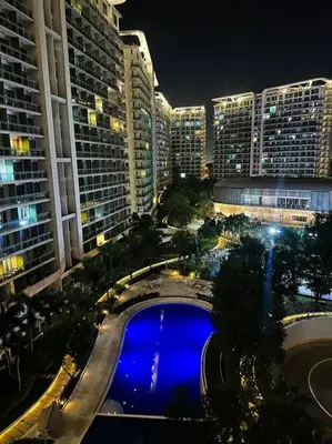 a view of a city at night with a pool at Casa Alivia at Azure UrbanResort in Manila