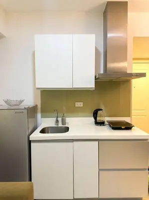 a kitchen with white cabinets and a sink at Casa Alivia at Azure UrbanResort in Manila