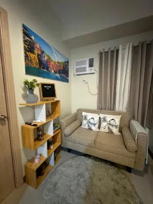 a living room with a couch and a window at The J-MA UltiEscape Charm Residences Condo in Manila