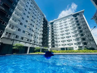 a swimming pool in front of a building at The J-MA UltiEscape Charm Residences Condo in Manila
