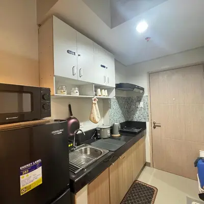 a small kitchen with a sink and a microwave at The J-MA UltiEscape Charm Residences Condo in Manila