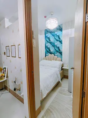 a bedroom with a bed with a painting on the wall at MOA Staycation Haven Cozy 1BR Retreat with Balcony at Shore 3 in Manila
