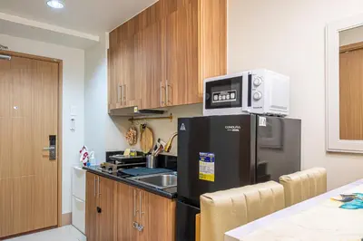 a kitchen with a black refrigerator and a microwave at MOA Staycation Haven Cozy 1BR Retreat with Balcony at Shore 3 in Manila