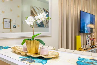 a table with a vase with white flowers on it at MOA Staycation Haven Cozy 1BR Retreat with Balcony at Shore 3 in Manila