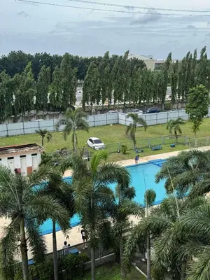 a view of the pool from the balcony of a resort with palm trees at Fablo Getaway Staycation in Santa Rosa