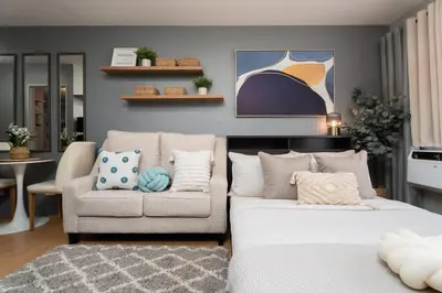 a living room with a bed and a couch at Newly Renovated Pasig Studio with Pool and Fiber Wi-Fi in Manila