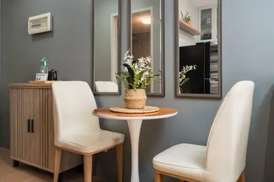 a table with two white chairs and a mirror at Newly Renovated Pasig Studio with Pool and Fiber Wi-Fi in Manila