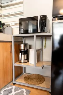 a microwave on a shelf in a kitchen at Newly Renovated Pasig Studio with Pool and Fiber Wi-Fi in Manila