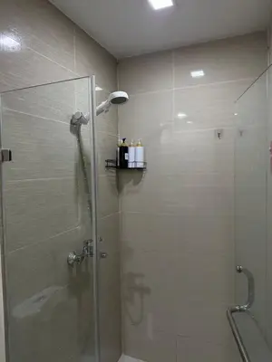 a bathroom with a shower with a glass door at Comfy 1BR Across International Airport in Manila