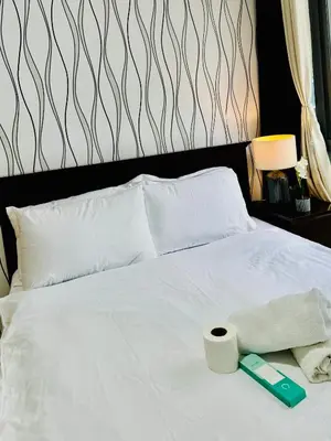 a white bed with a roll of toilet paper on it at Comfy 1BR Across International Airport in Manila