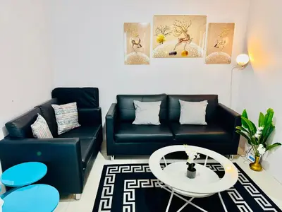a living room with two black couches and a table at Comfy 1BR Across International Airport in Manila