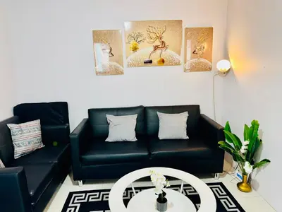 a living room with a black couch and a table at Comfy 1BR Across International Airport in Manila