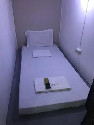 a bed in a small room with a cell phone on it at RDC - Mariveles Transient Capsule in Manila
