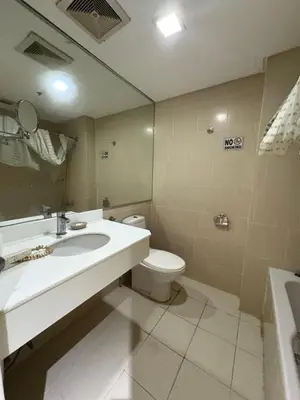 a bathroom with a sink and a toilet and a mirror at Studio deluxe cozy staycation Antel Spa Residences in Manila