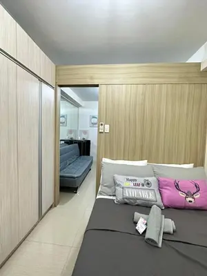 a bedroom with a large bed with purple pillows at shore staycation 559 in Manila
