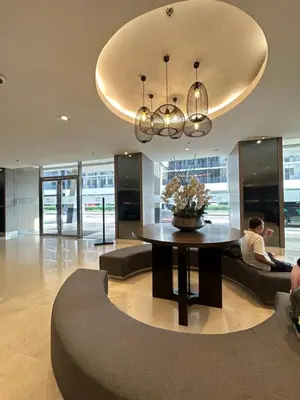 a man sitting on a couch in a lobby with a table at shore staycation 559 in Manila