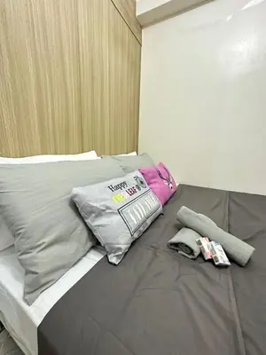a bed with two pillows and a bag on it at shore staycation 559 in Manila