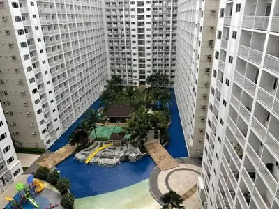 an aerial view of a pool in the middle of two tall buildings at shore staycation 559 in Manila