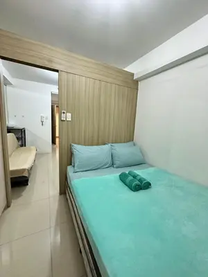 a bedroom with a bed with blue pillows on it at shore staycation 559 in Manila