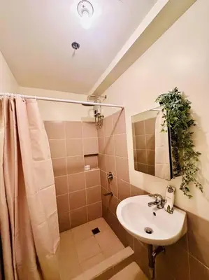a bathroom with a sink and a shower at 1-BR Condo with Pool & Skyline Views in Pasig in Manila
