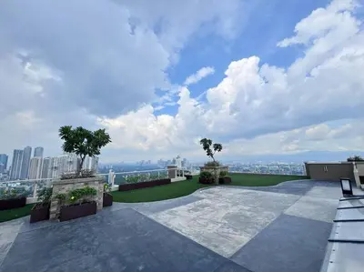 an outdoor patio with a view of the city at 1-BR Condo with Pool & Skyline Views in Pasig in Manila