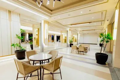 a lobby of a hotel with a table and chairs at 1-BR Condo with Pool & Skyline Views in Pasig in Manila