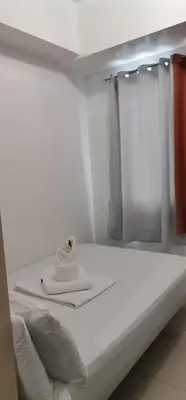 a white bed with a towel on top of it at Moa Staycation pasay by mj in Manila