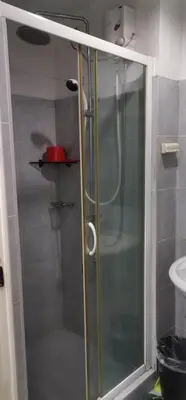 a shower with a glass door in a bathroom at Moa Staycation pasay by mj in Manila