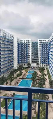 a view of a resort with a pool and buildings at Moa Staycation pasay by mj in Manila
