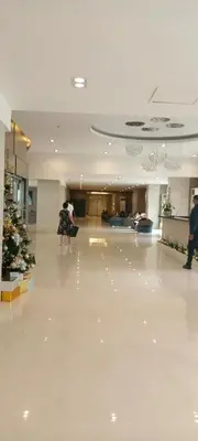 a woman standing in a large lobby with a christmas tree at Moa Staycation pasay by mj in Manila