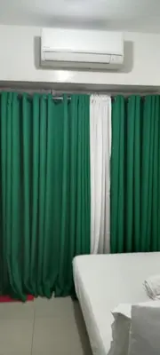 a room with green and white curtains and a bed at Moa Staycation pasay by mj in Manila