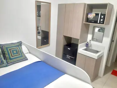 a room with a bed with a sink and a mirror at Hotel in Mandaluyong in Manila