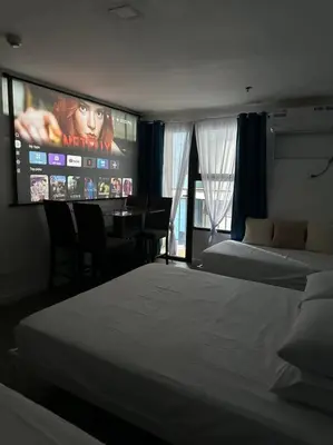 a hotel room with two beds and a tv at Studio w projector Wifi Netflix and pool access in ADB Tower Ortigas CBD in Manila