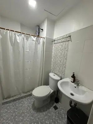 a bathroom with a toilet and a sink at Studio w projector Wifi Netflix and pool access in ADB Tower Ortigas CBD in Manila