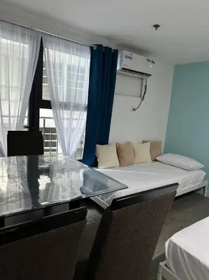 a room with a bed and a couch and a window at Studio w projector Wifi Netflix and pool access in ADB Tower Ortigas CBD in Manila