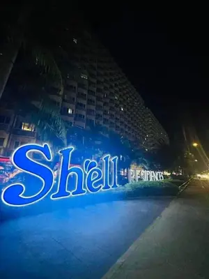 a lit up sign in front of a building at night at shell staycation in Manila