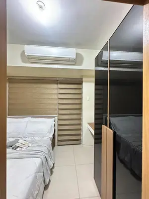 a room with two beds and a air conditioner at shell staycation in Manila