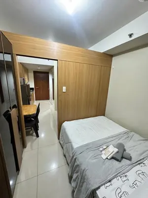 a bedroom with a bed and a desk in it at shell staycation in Manila