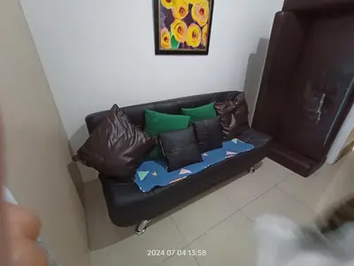 a black leather couch with pillows in a living room at Sea res moa by Elsie D in Manila